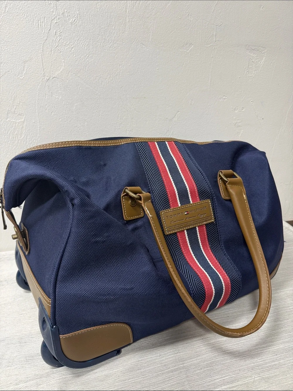 Tommy Hilfiger Navy rolling Duffel with Red & White Center Stripe  carry on